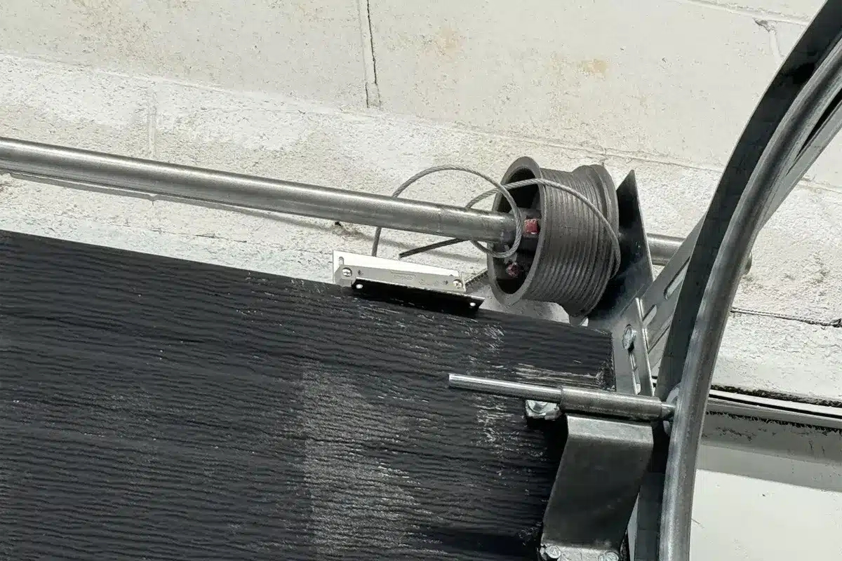 A technician repairing a broken garage door spring in Laval