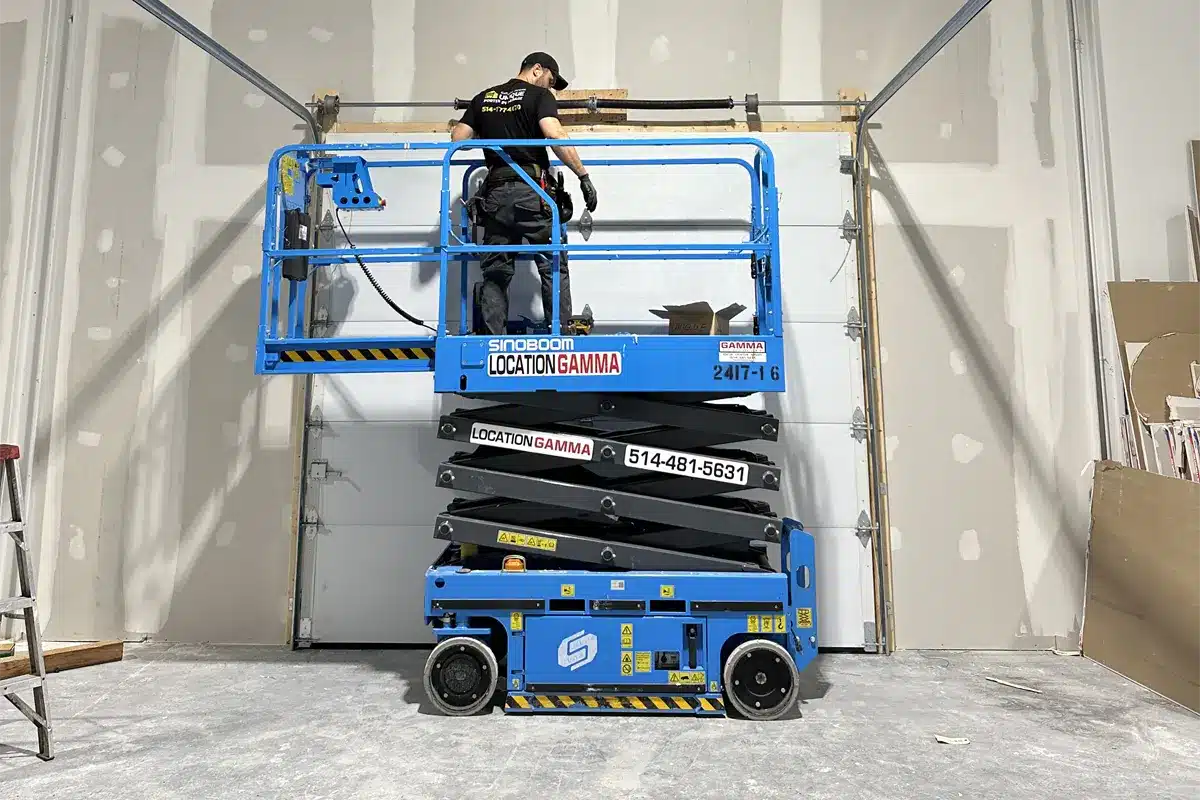a garage door repair specialist using advance equipment like scissor lift to install a new garage door in Anjou