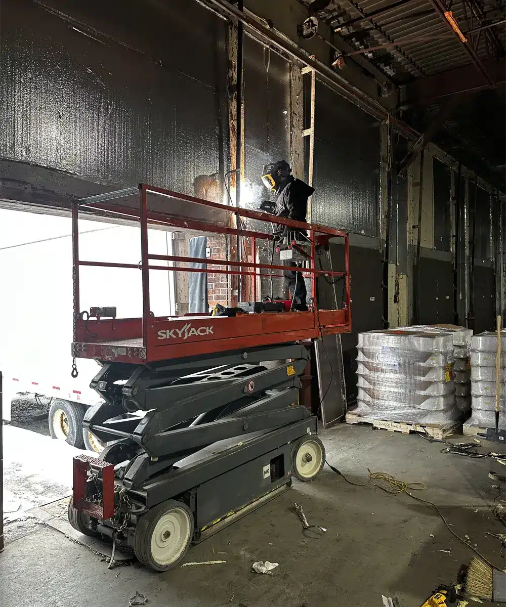 a contractor from Unique Garage Door running an inspection on a malfunctioning garage door in Montreal