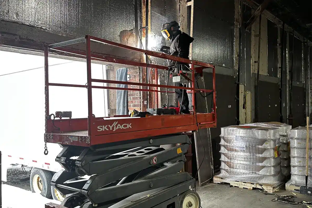 A technician from Unique Garage Doors repairing a garage doors with advance equipment for a quality services in Terrebonne