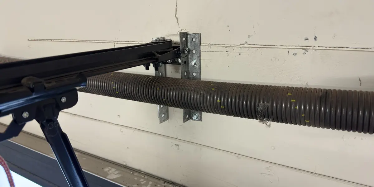 a loose spring in garage door is being replaced by technicians