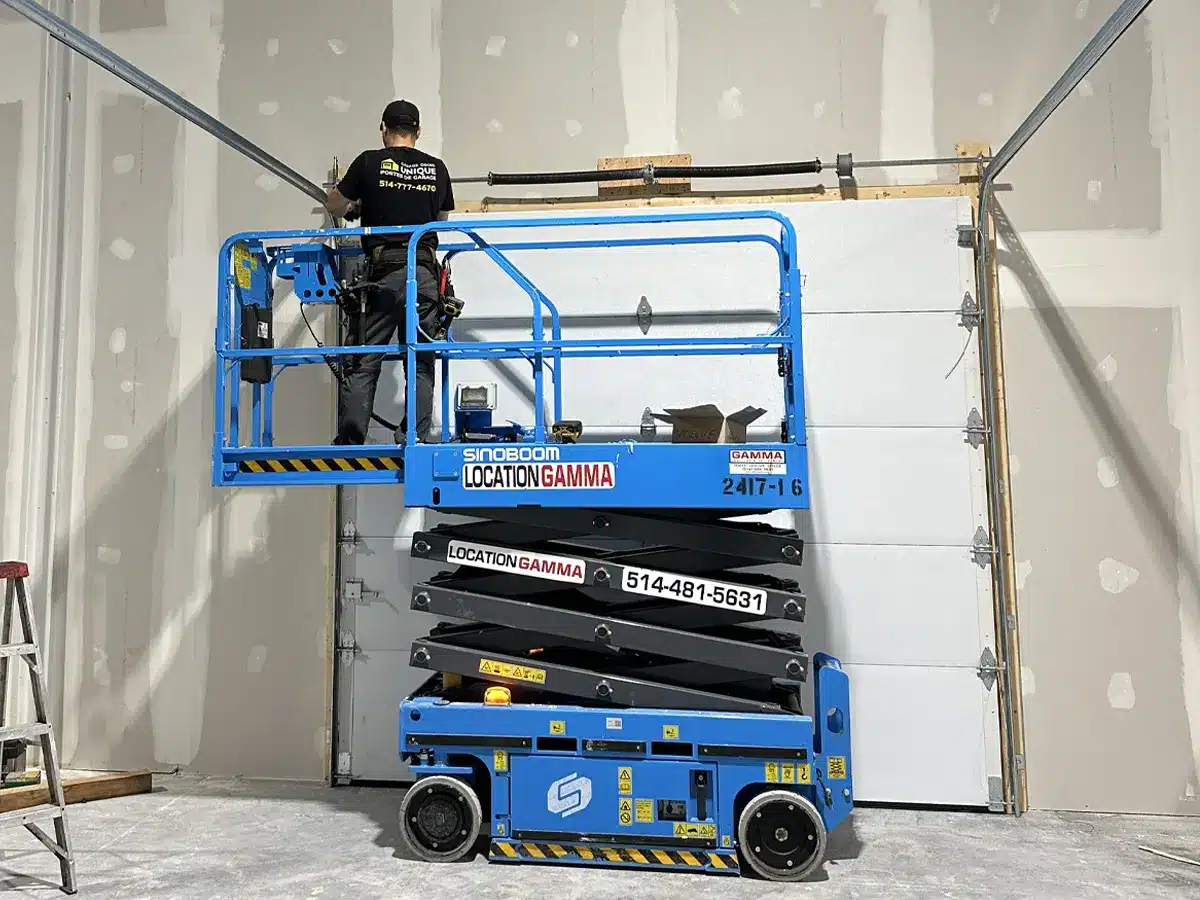 a garage door repair specialist using advance equipment like scissor lift to install a new garage door in Dorval