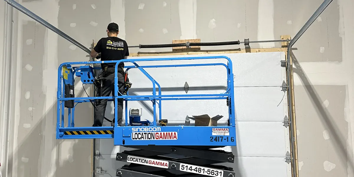 a garage door repair and maintenance specialist using advance equipment like scissor lift to install a new garage door in Lorraine