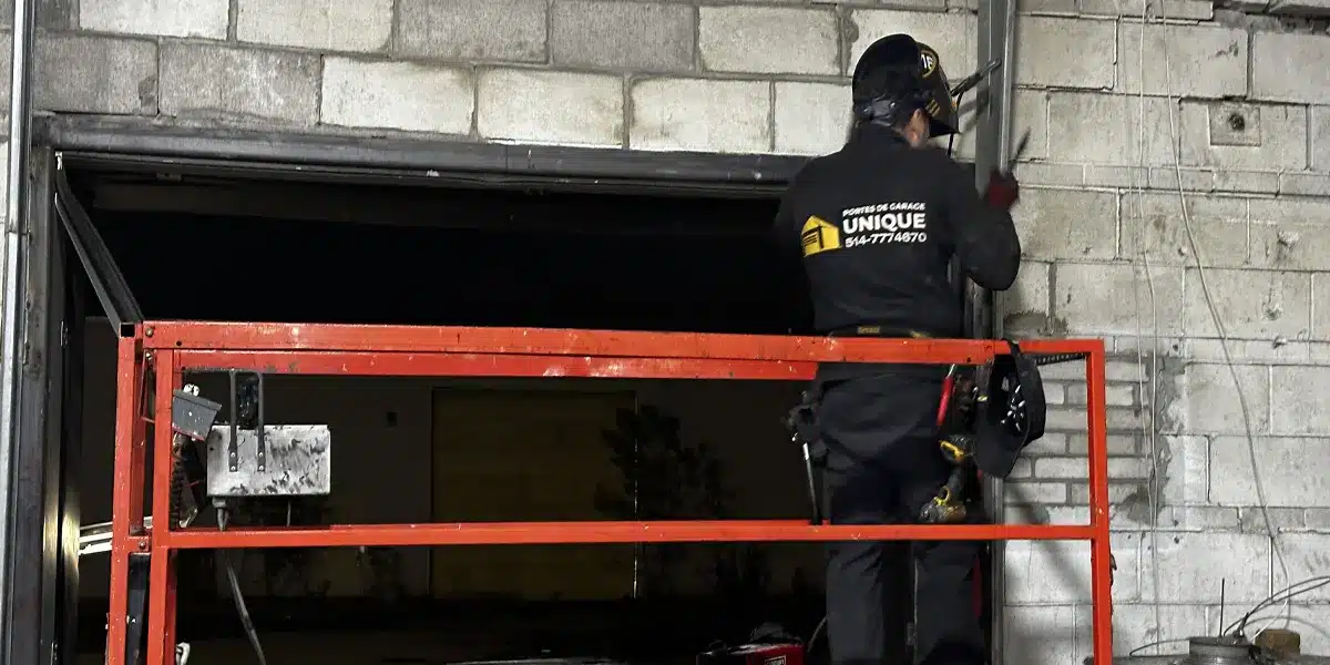 un spécialiste de l'entretien des portes de garage utilisant des équipements de pointe comme un élévateur à ciseaux pour installer une nouvelle porte de garage à Terrebonne